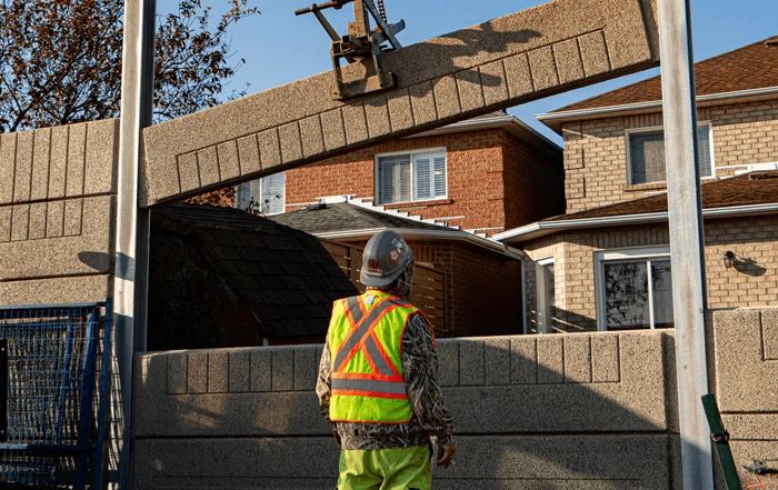 Constructor worker watching craine lower barrier wall blocks